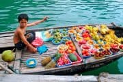 niño vende frutas en barca en Vietnam